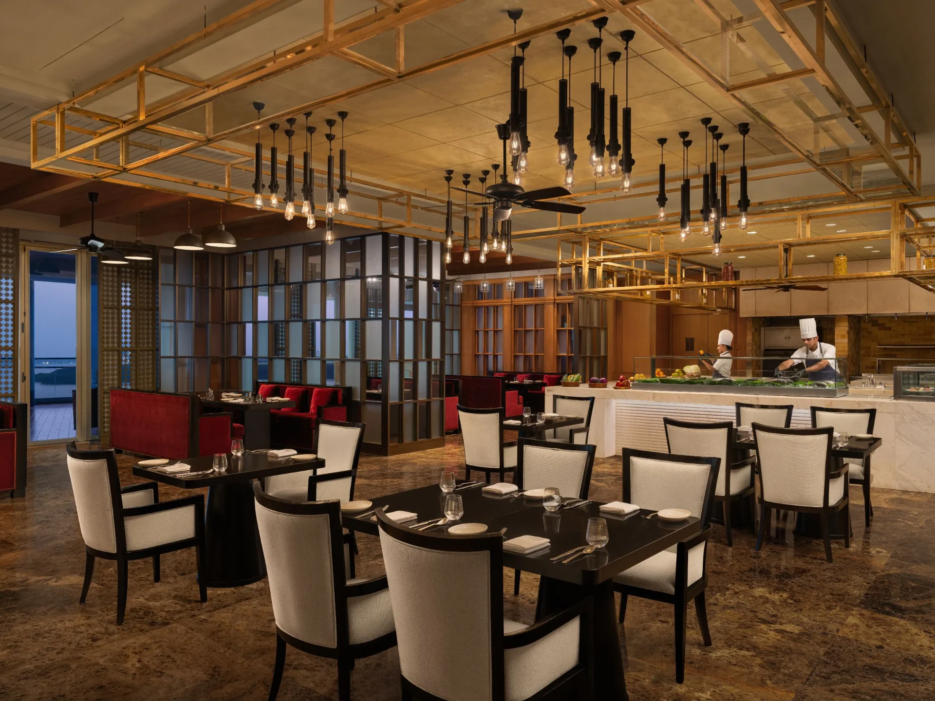 Restaurant interior with open kitchen and warm brass lighting